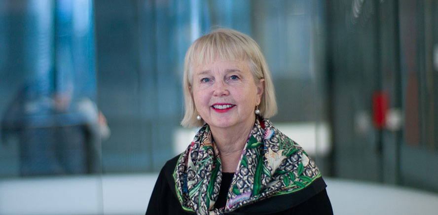 Head shot of Peggy O'Neal, Chair of Vanguard Super, wearing a scarf, smiling at the camera. 